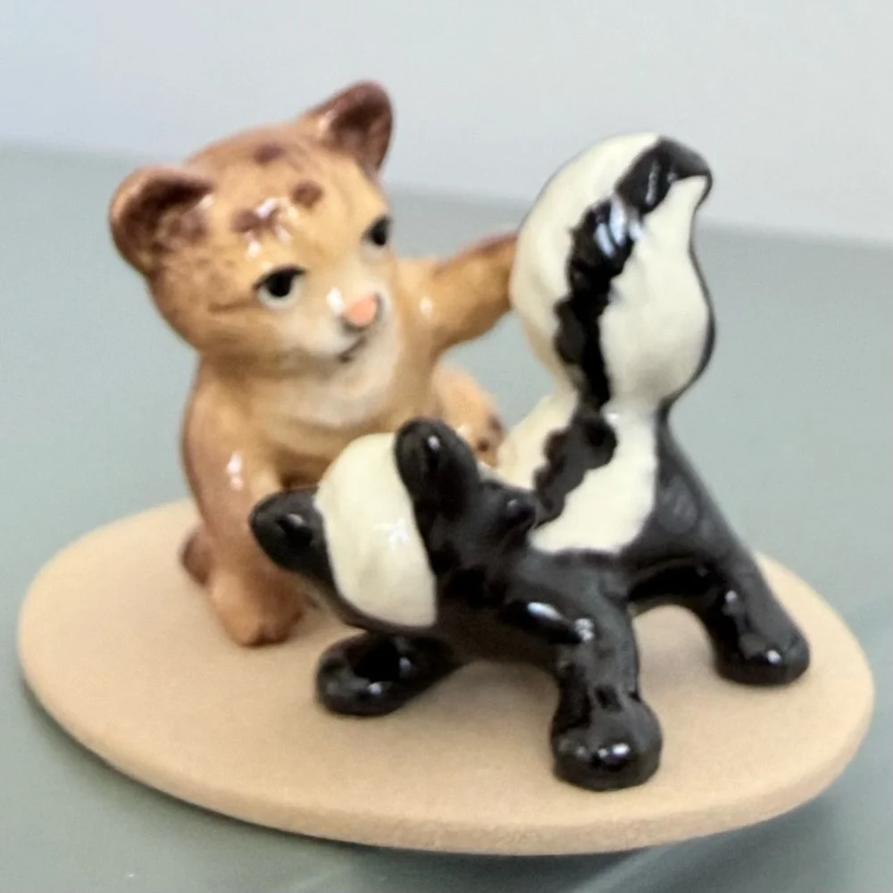 Vintage retired Hagen Renaker bobcat and skunk babies on base